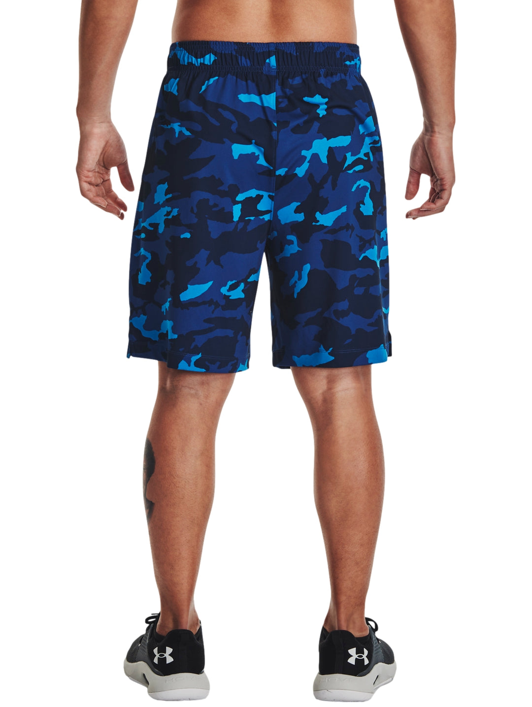 Hombre vistiendo shorts deportivos con estampado de camuflaje en tonos azules.