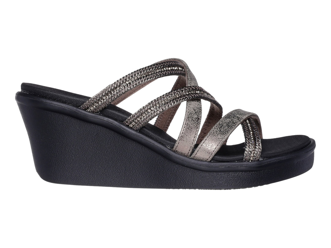 Sandalia Skechers de cuña negra con correas cruzadas en tono gris brillante para mujer.