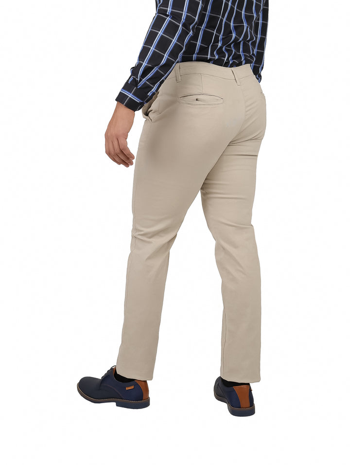 Hombre vistiendo un pantalón chino de color hueso con corte recto y zapatos azules.