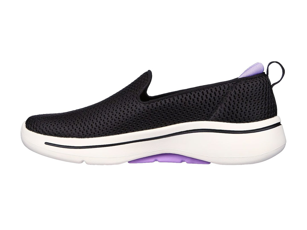 Tenis Skechers negros estilo slip-on con suela blanca y detalles en color lavanda.