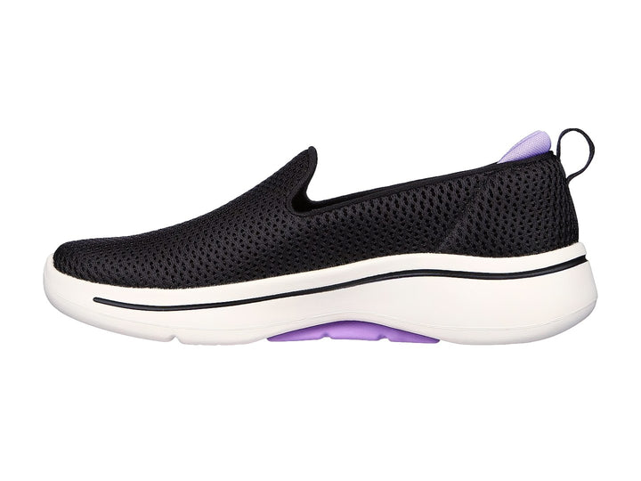 Tenis Skechers negros estilo slip-on con suela blanca y detalles en color lavanda.