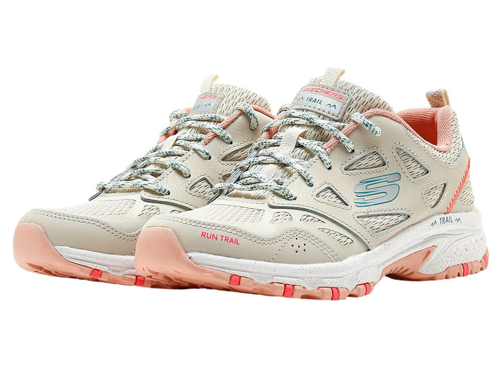 Zapato deportivo SKECHERS color beige con detalles en rosa y azul para actividades al aire libre.