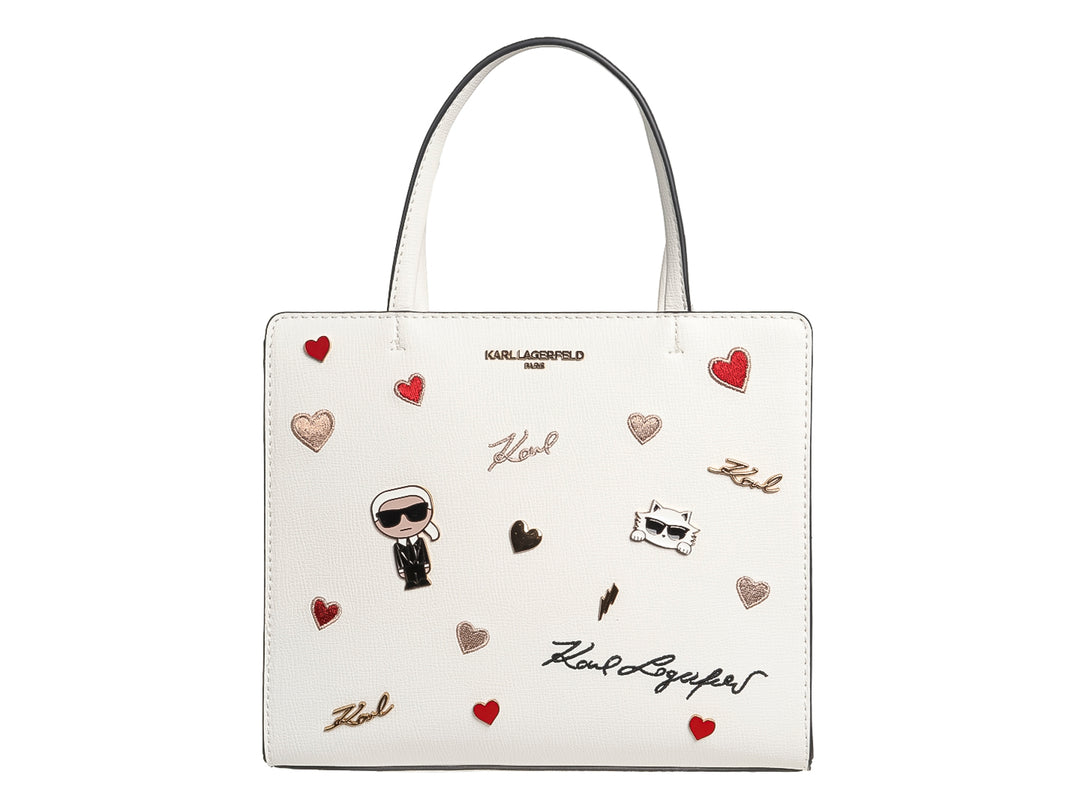 Bolso blanco rectangular de Karl Lagerfeld con estampados de corazones rojos y dorados, y figuras gráficas.