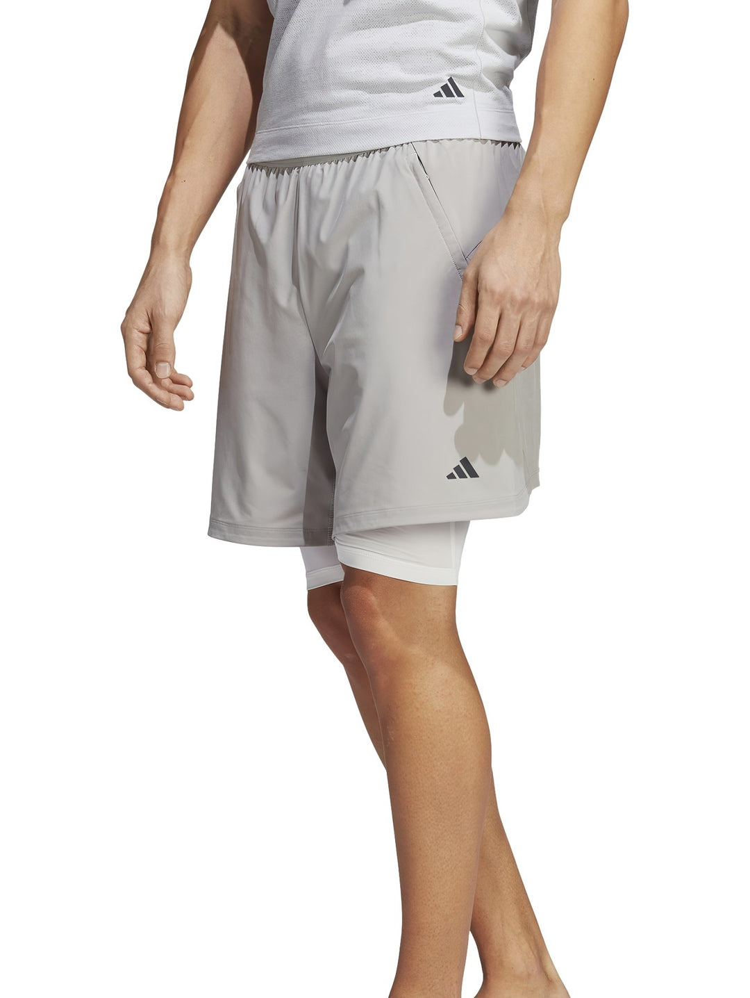 Hombre usando shorts de yoga 2 en 1 color gris de Adidas.