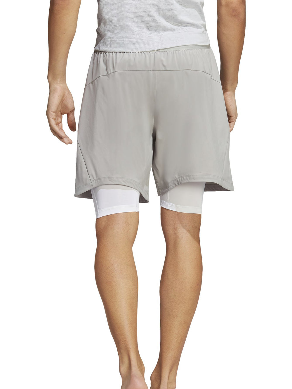 Hombre usando shorts de yoga 2 en 1 color gris de Adidas.