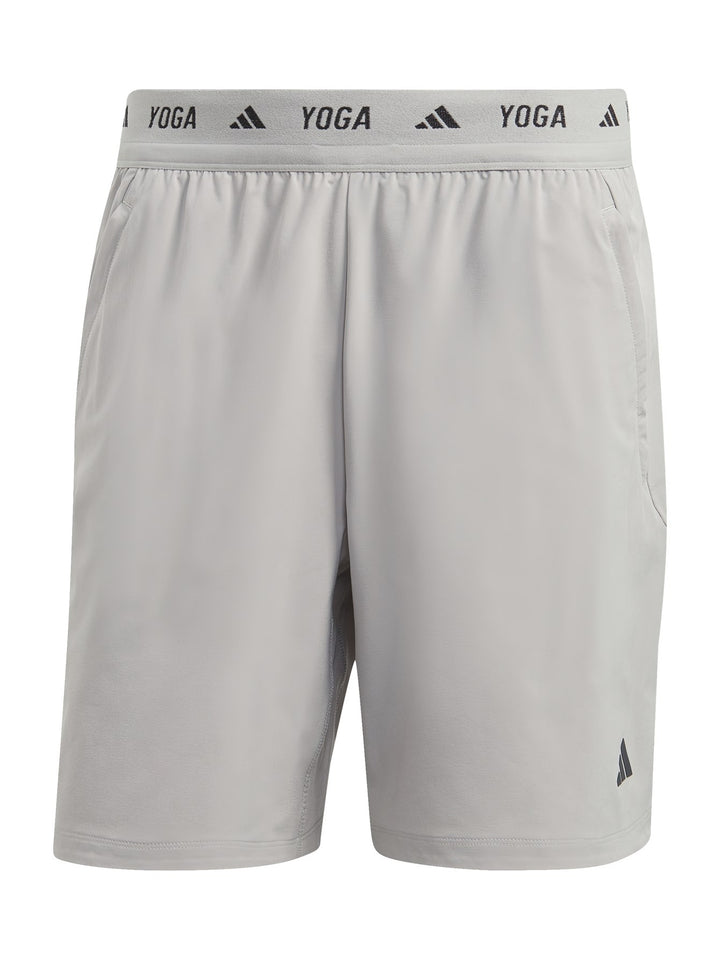 Hombre usando shorts de yoga 2 en 1 color gris de Adidas.
