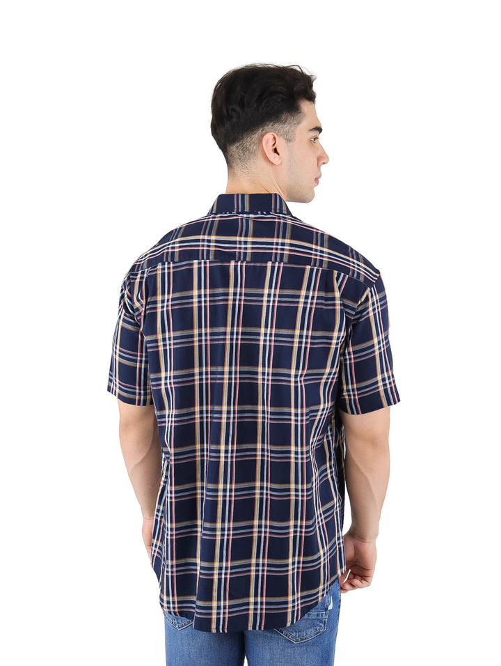 Hombre vistiendo camisa de manga corta a cuadros en color azul marino y rosa.