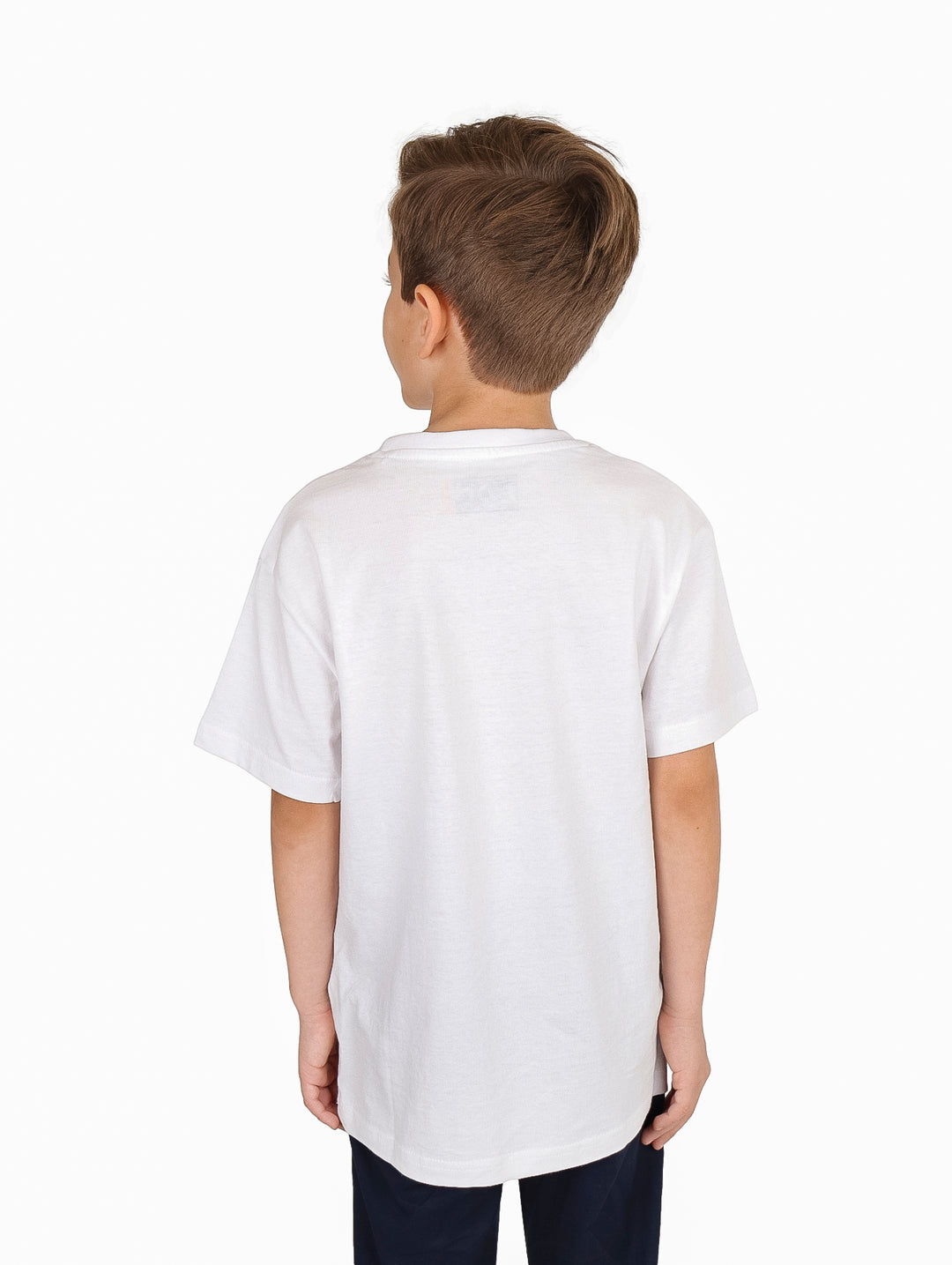 Niño vistiendo una camiseta blanca de manga corta con un estampado gráfico colorido de temática playera en el pecho.