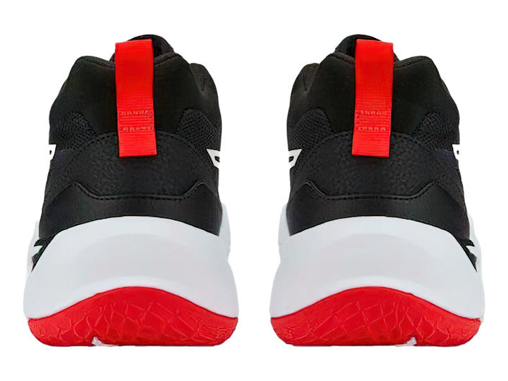 Tenis de baloncesto PUMA en color negro con suela blanca y detalles en rojo.