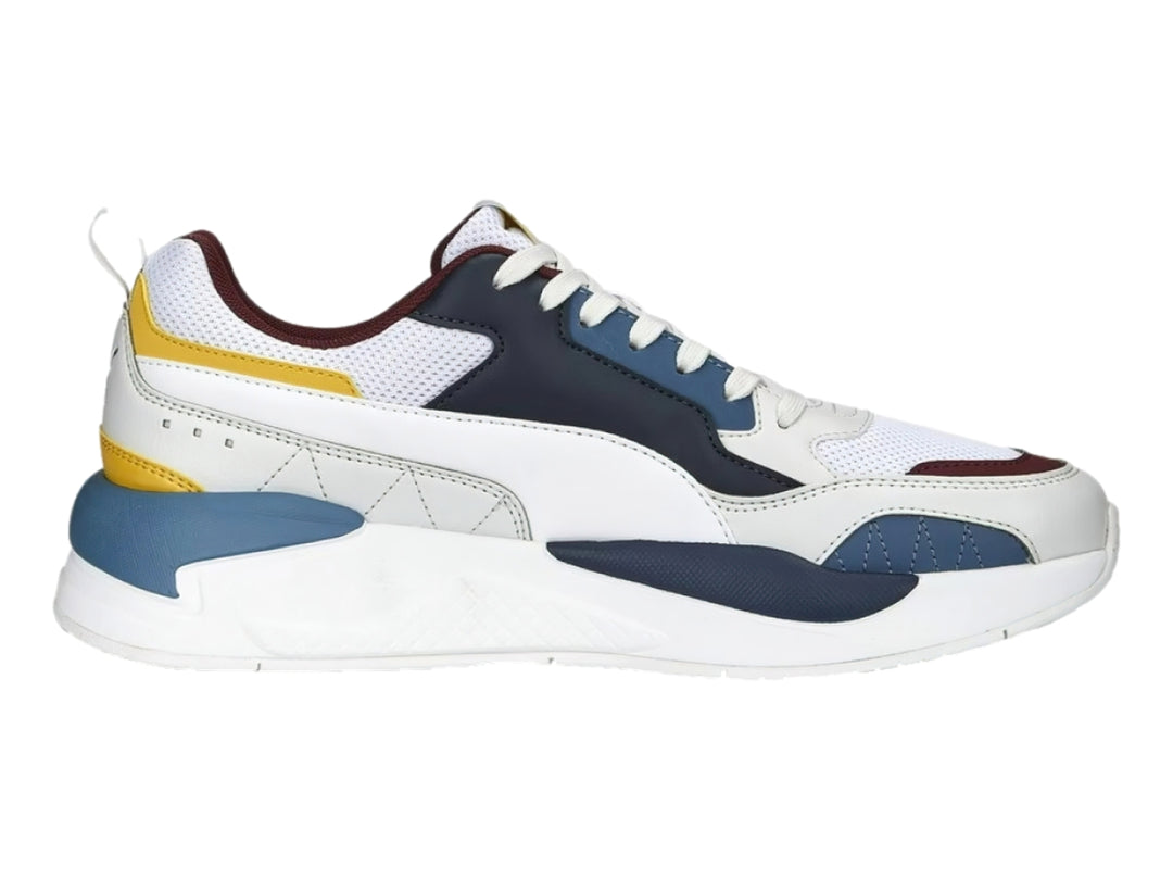 Tenis PUMA X-RAY 2 SQUARE blancos con detalles en azul marino, amarillo y guinda.