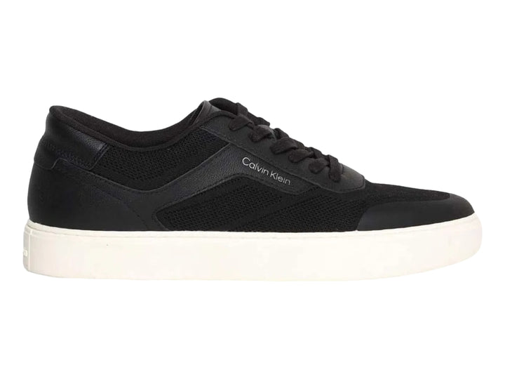 Tenis Calvin Klein negros de corte bajo con suela blanca y detalles en tejido.