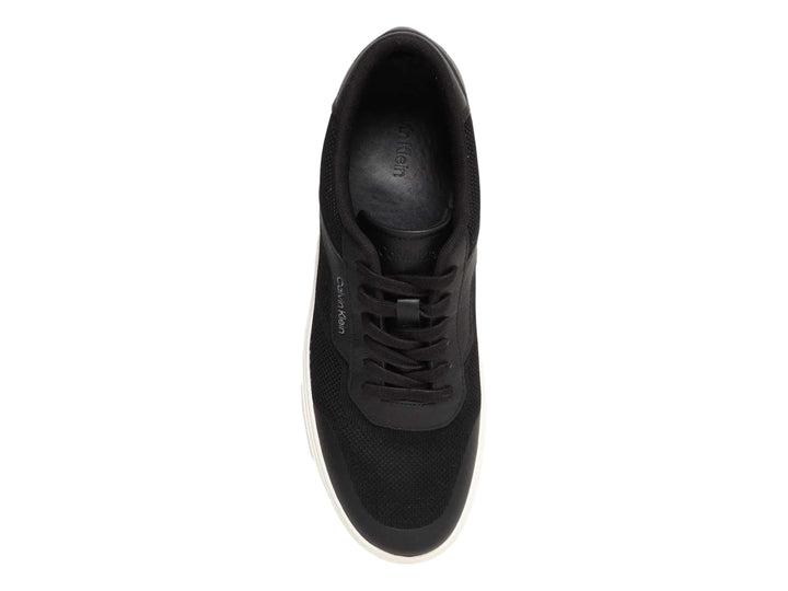 Tenis Calvin Klein negros de corte bajo con suela blanca y detalles en tejido.