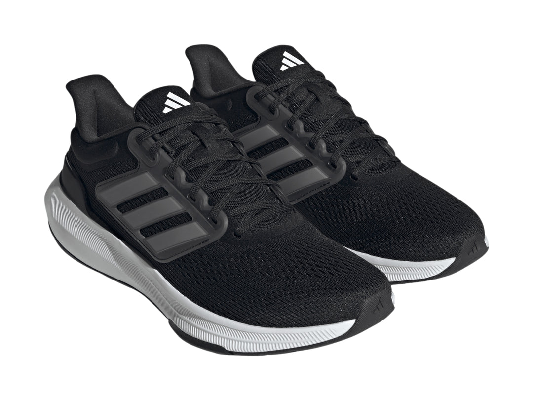 Tenis deportivos Adidas Ultrabounce color negro con suela blanca y detalles en gris.