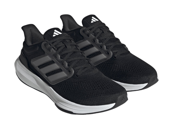 Tenis deportivos Adidas Ultrabounce color negro con suela blanca y detalles en gris.