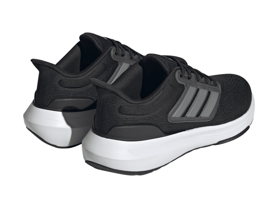 Tenis deportivos Adidas Ultrabounce color negro con suela blanca y detalles en gris.