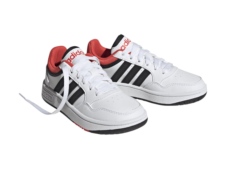 Tenis Adidas Hoops 3.0 en color blanco con franjas negras y detalles en rojo, diseño deportivo para niños.