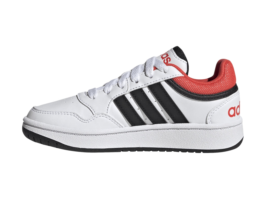 Tenis Adidas Hoops 3.0 en color blanco con franjas negras y detalles en rojo, diseño deportivo para niños.