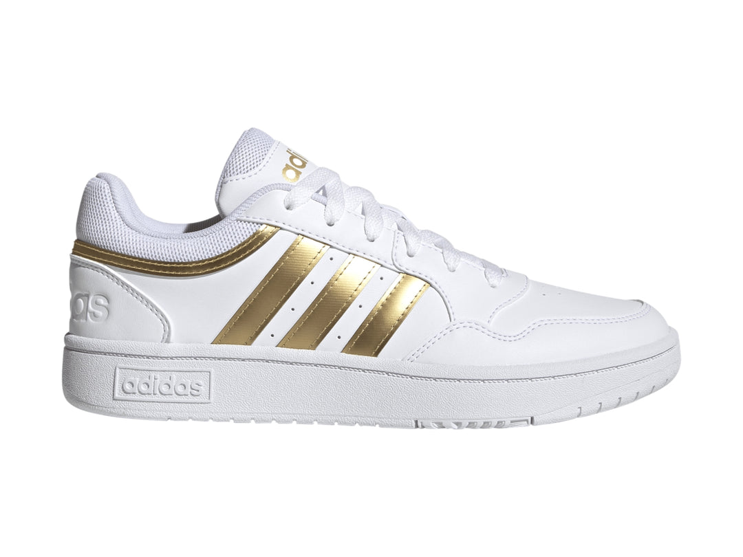 Tenis Adidas Hoops 3.0 en color blanco con las tres franjas laterales y detalles en dorado mate.