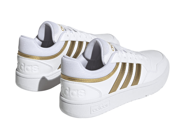 Tenis Adidas Hoops 3.0 en color blanco con las tres franjas laterales y detalles en dorado mate.