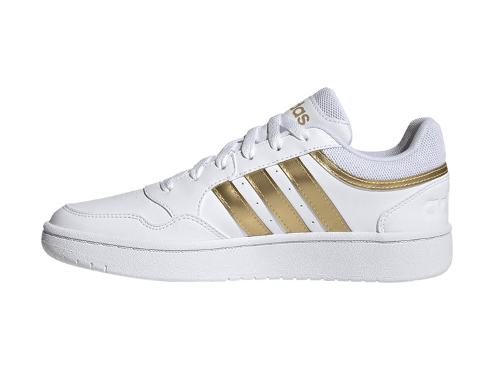 Tenis Adidas Hoops 3.0 en color blanco con las tres franjas laterales y detalles en dorado mate.