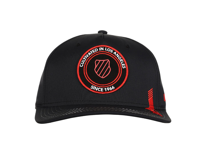 Gorra K-Swiss color negro con logotipo circular bordado en rojo en el frente y detalle lateral rojo.