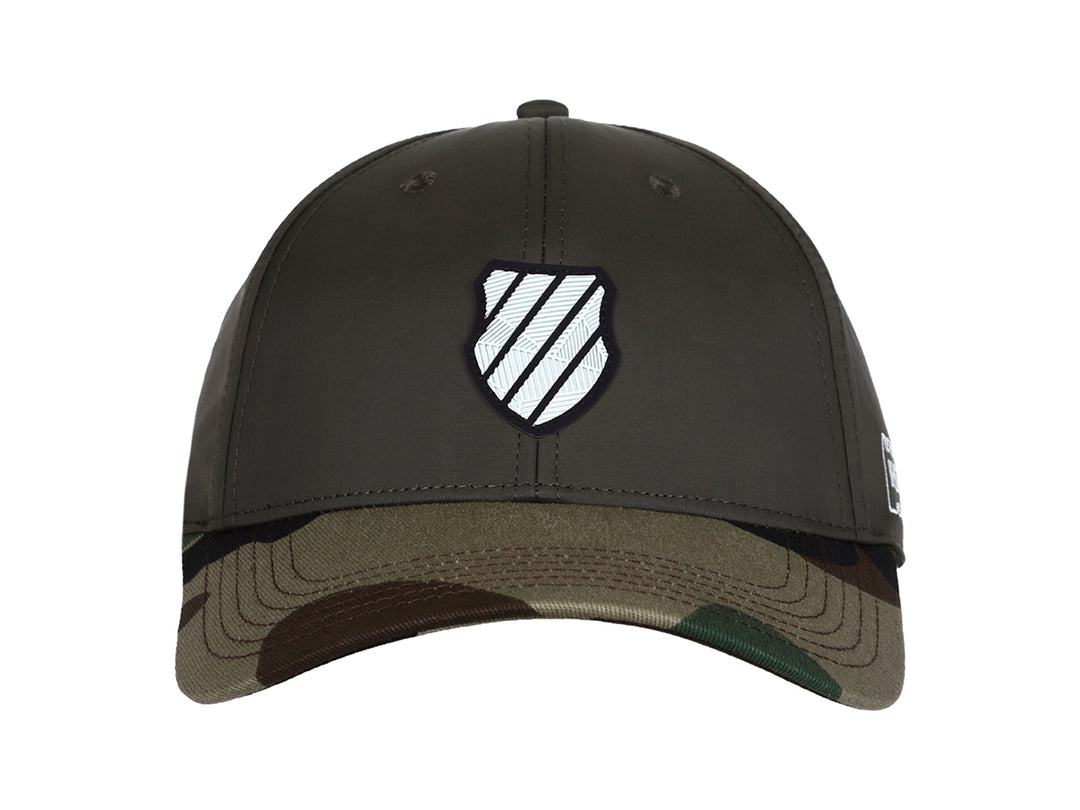 Gorra K-Swiss color olivo con visera en estampado de camuflaje y logo blanco frontal.