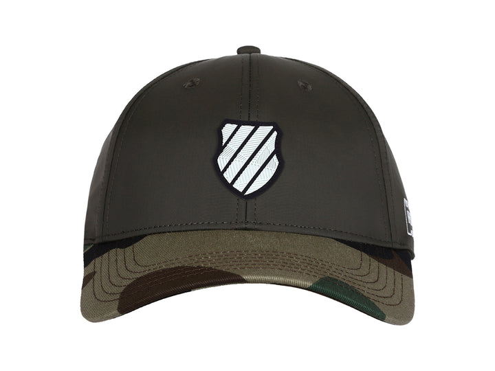 Gorra K-Swiss color olivo con visera en estampado de camuflaje y logo blanco frontal.