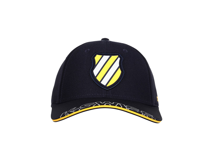 Gorra K-Swiss color marino con visera curva, detalles en amarillo y logotipo frontal.