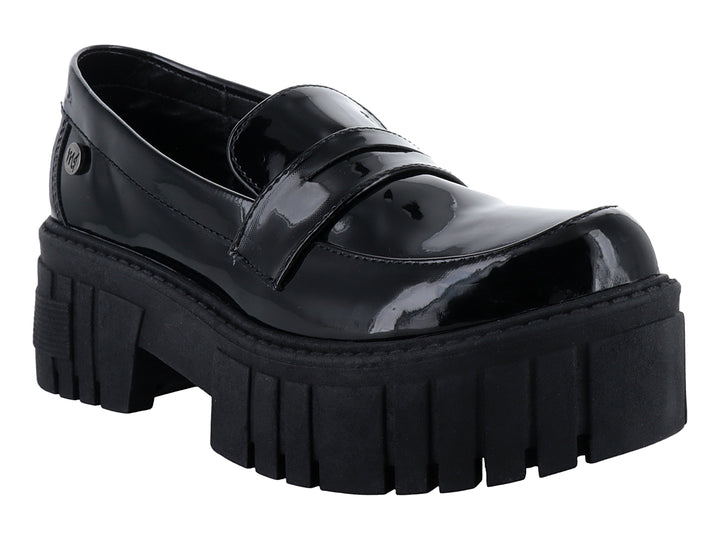 Zapato tipo mocasín de charol negro con suela de plataforma gruesa y dentada.