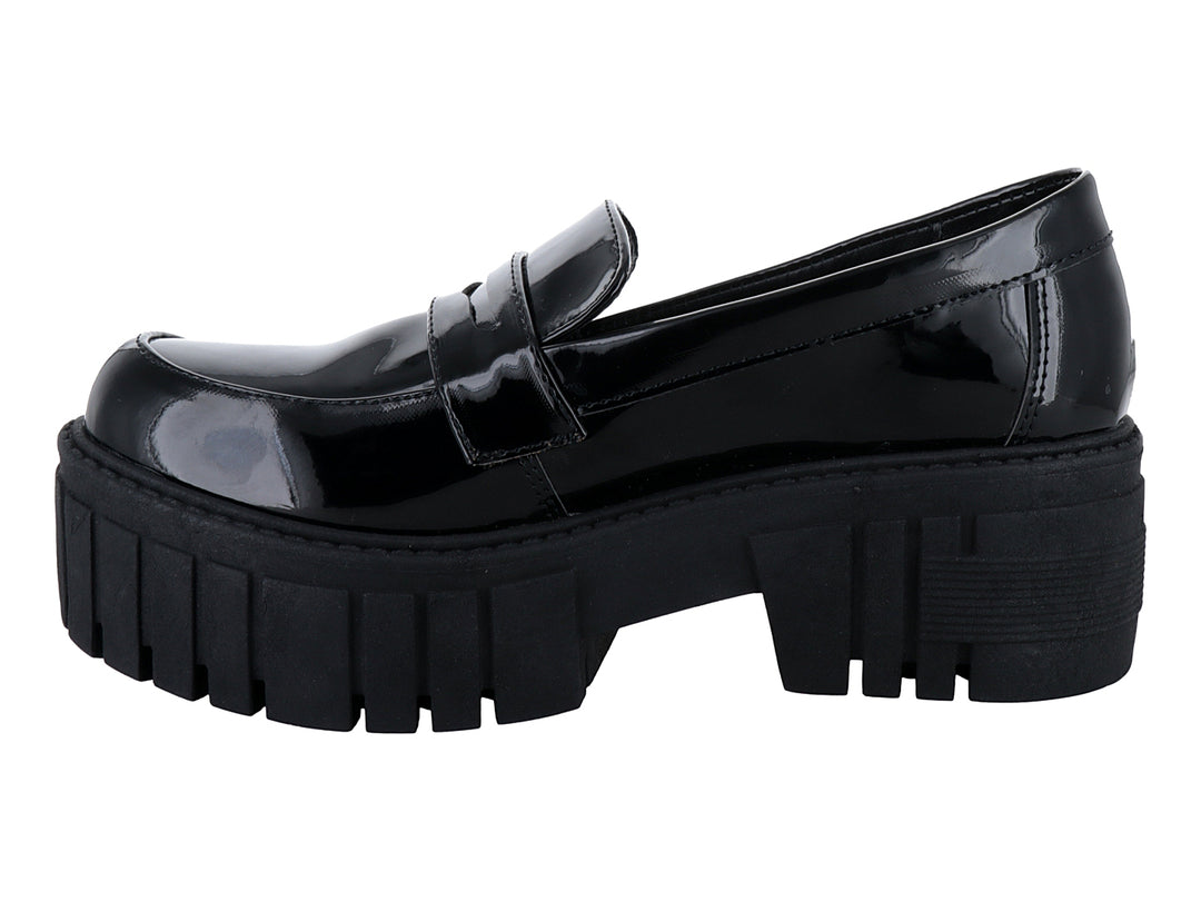 Zapato tipo mocasín de charol negro con suela de plataforma gruesa y dentada.