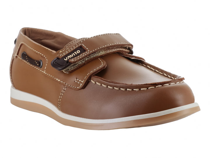 Zapato tipo mocasín color camel para niño con correa de ajuste y suela blanca.