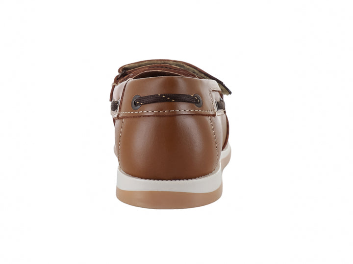 Zapato tipo mocasín color camel para niño con correa de ajuste y suela blanca.