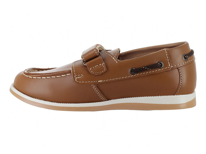 Zapato tipo mocasín color camel para niño con correa de ajuste y suela blanca.