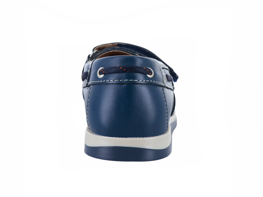 Zapato náutico para niño en color azul marino con suela blanca y correa de ajuste con velcro.