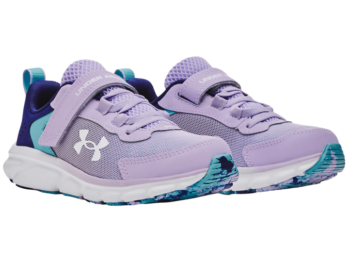 Tenis deportivos Under Armour para niña en color morado con detalles azules y suela blanca.
