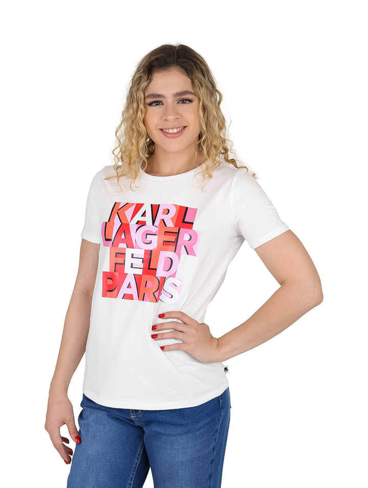 Mujer con camiseta blanca de manga corta y estampado gráfico en rojo y rosa de Karl Lagerfeld.