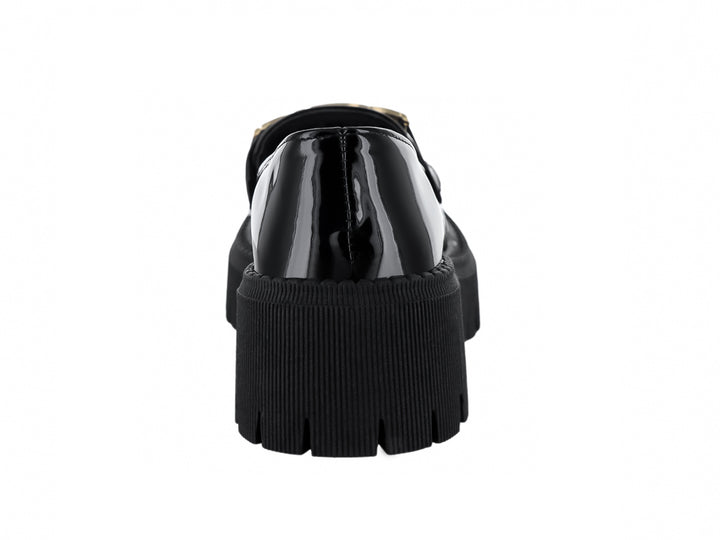 Zapato mocasín de charol negro con hebilla dorada y suela de plataforma gruesa dentada.