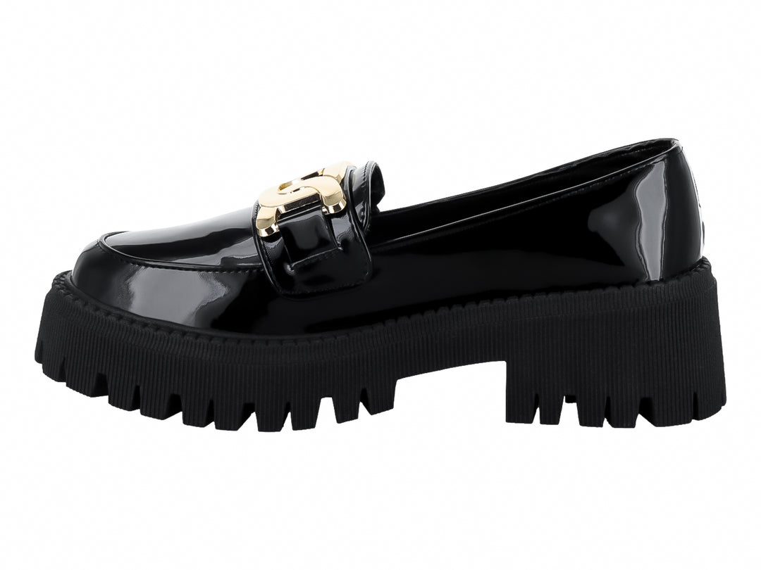 Zapato mocasín de charol negro con hebilla dorada y suela de plataforma gruesa dentada.