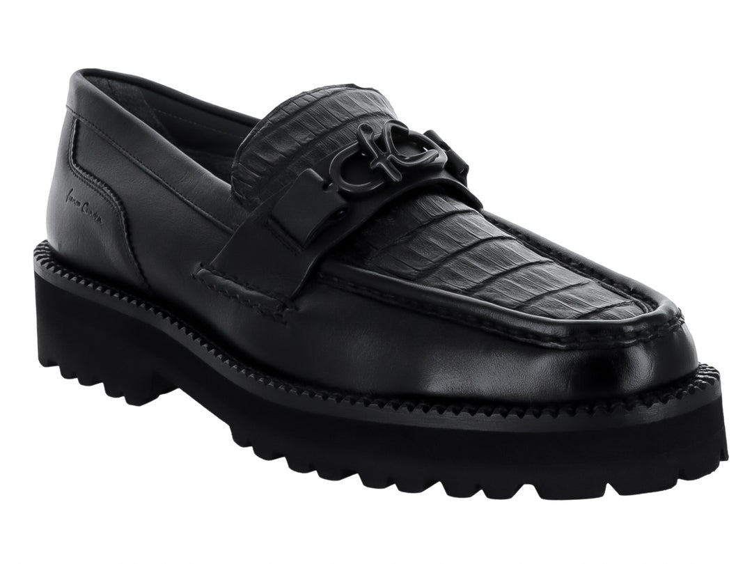 Zapato mocasín Cuadra en color negro con textura de piel de caimán y suela gruesa dentada.
