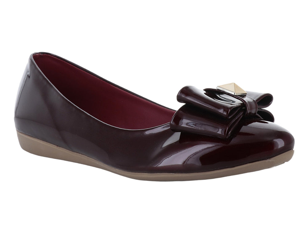 Zapato plano color vino en acabado charol brillante con detalle de moño decorativo en la parte frontal.