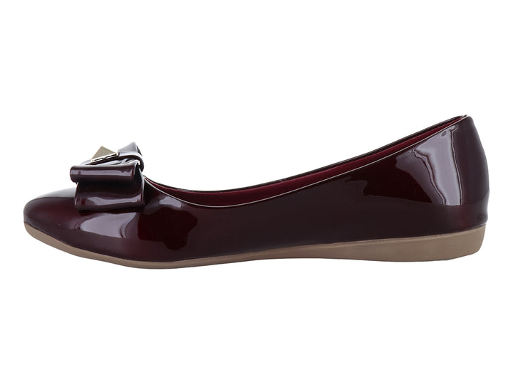 Zapato plano color vino en acabado charol brillante con detalle de moño decorativo en la parte frontal.