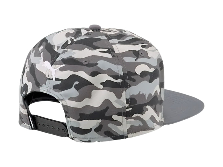Gorra PUMA de visera plana con estampado de camuflaje en tonos grises y logotipo blanco frontal.