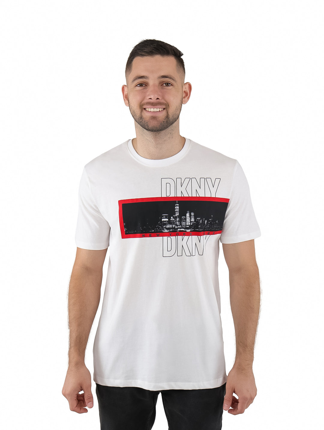 Hombre vistiendo playera blanca de manga corta marca DKNY con estampado gráfico frontal en rojo y negro.