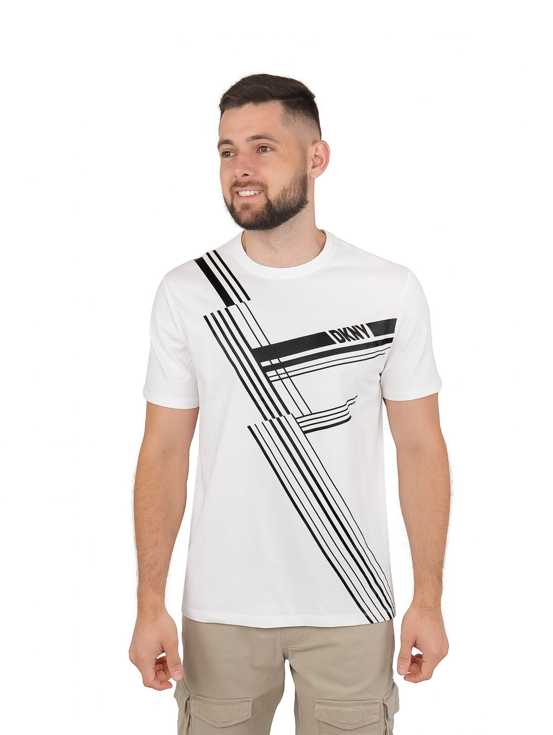 Hombre vistiendo playera blanca de manga corta con diseño de líneas negras y rojas y logo DKNY.