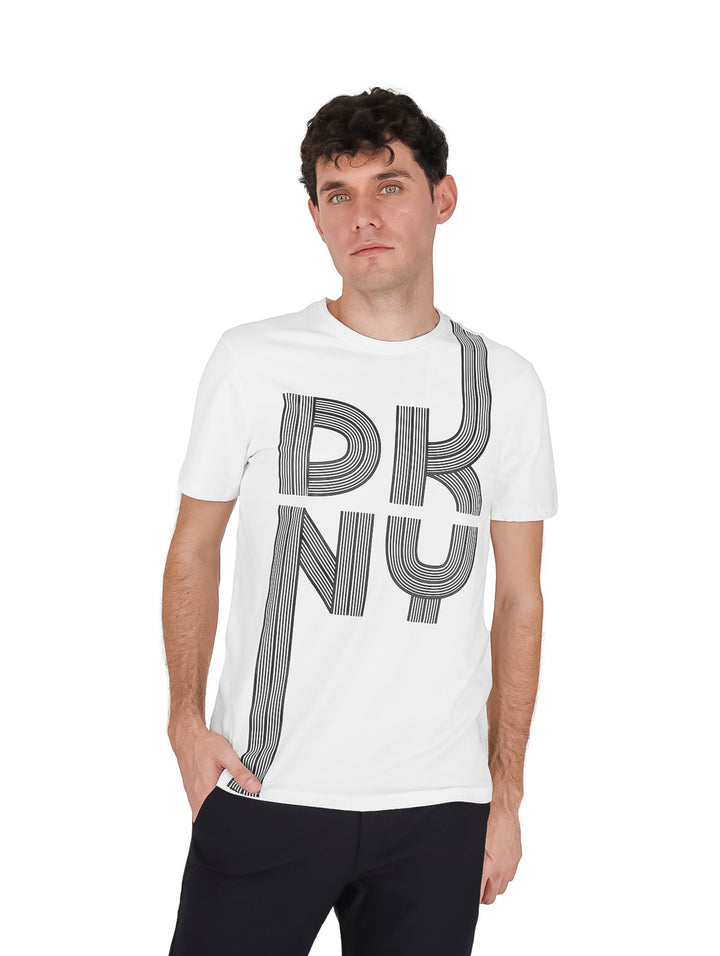 Hombre vistiendo playera blanca de manga corta con estampado gráfico de DKNY en el frente.