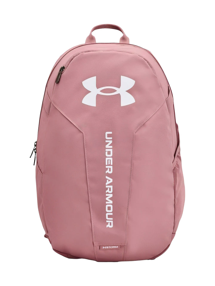 Mochila Under Armour Hustle Lite en color rosa con logotipo blanco frontal y asa superior.