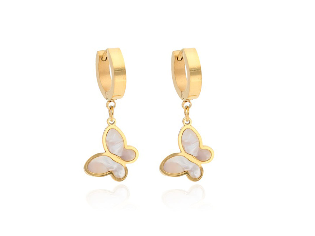 Par de pendientes dorados con dijes colgantes en forma de mariposa blanca y marco oro.
