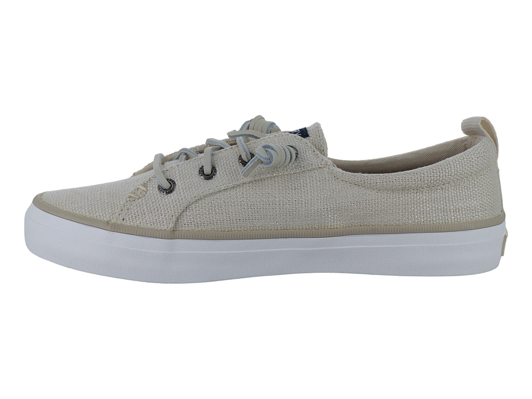 Tenis Sperry color off white de tela con cordones y suela blanca plana.