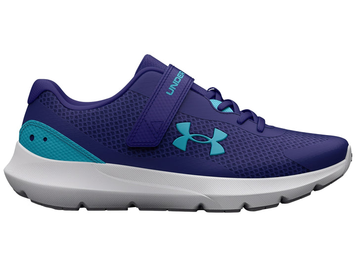 Tenis deportivos Under Armour color azul con detalles en turquesa, suela blanca y cierre de correa con velcro.