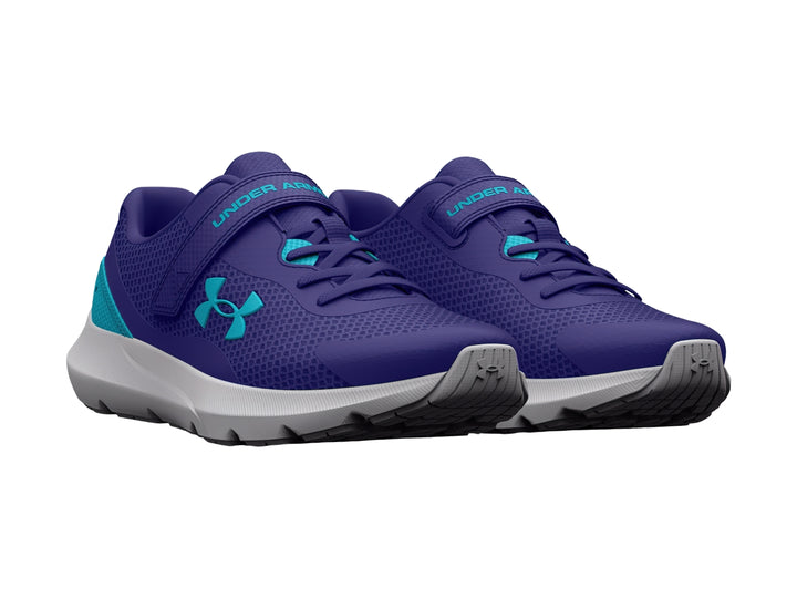 Tenis deportivos Under Armour color azul con detalles en turquesa, suela blanca y cierre de correa con velcro.
